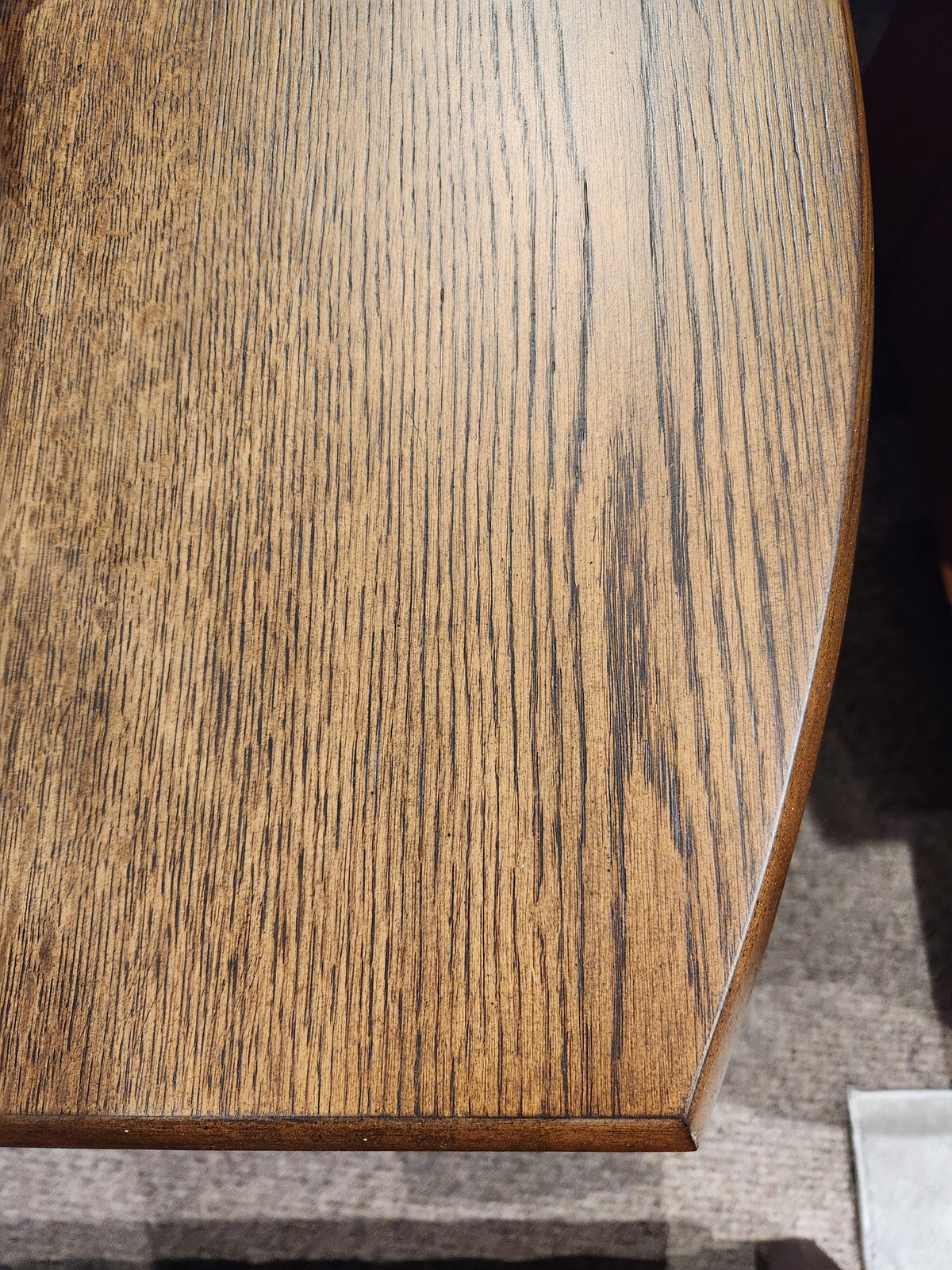 Close-up of the Magnussen T6385 - Phoebe Rectangular End Table in Sienna Brown with grain patterns and curved edge.