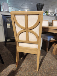 Magnussen D6480-Coventry dining chair: light wood, geometric back, cream upholstery, and Honey Maple finish.