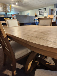 Magnussen D6480-Coventry 7pc Dining Set in Honey Maple with cushioned chairs, displayed among home décor.