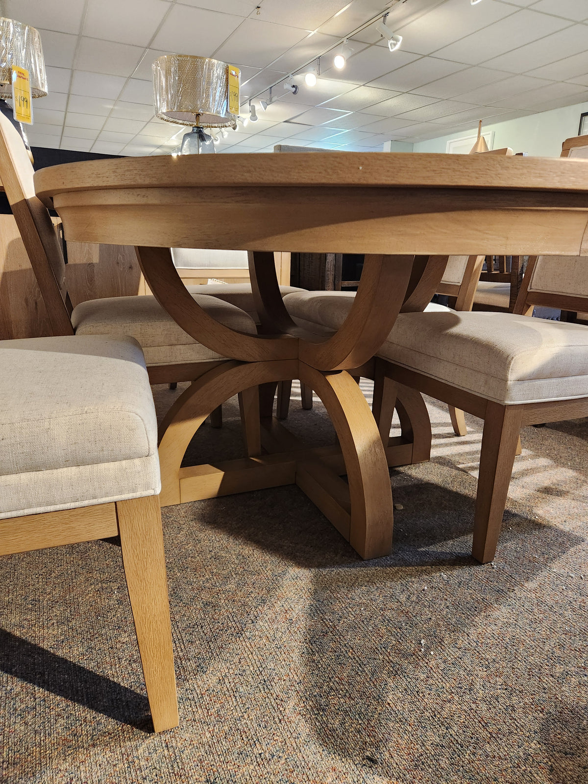 The Magnussen D6480-Coventry 7pc Dining Set features a honey maple finish and curved pedestal base with upholstered chairs.