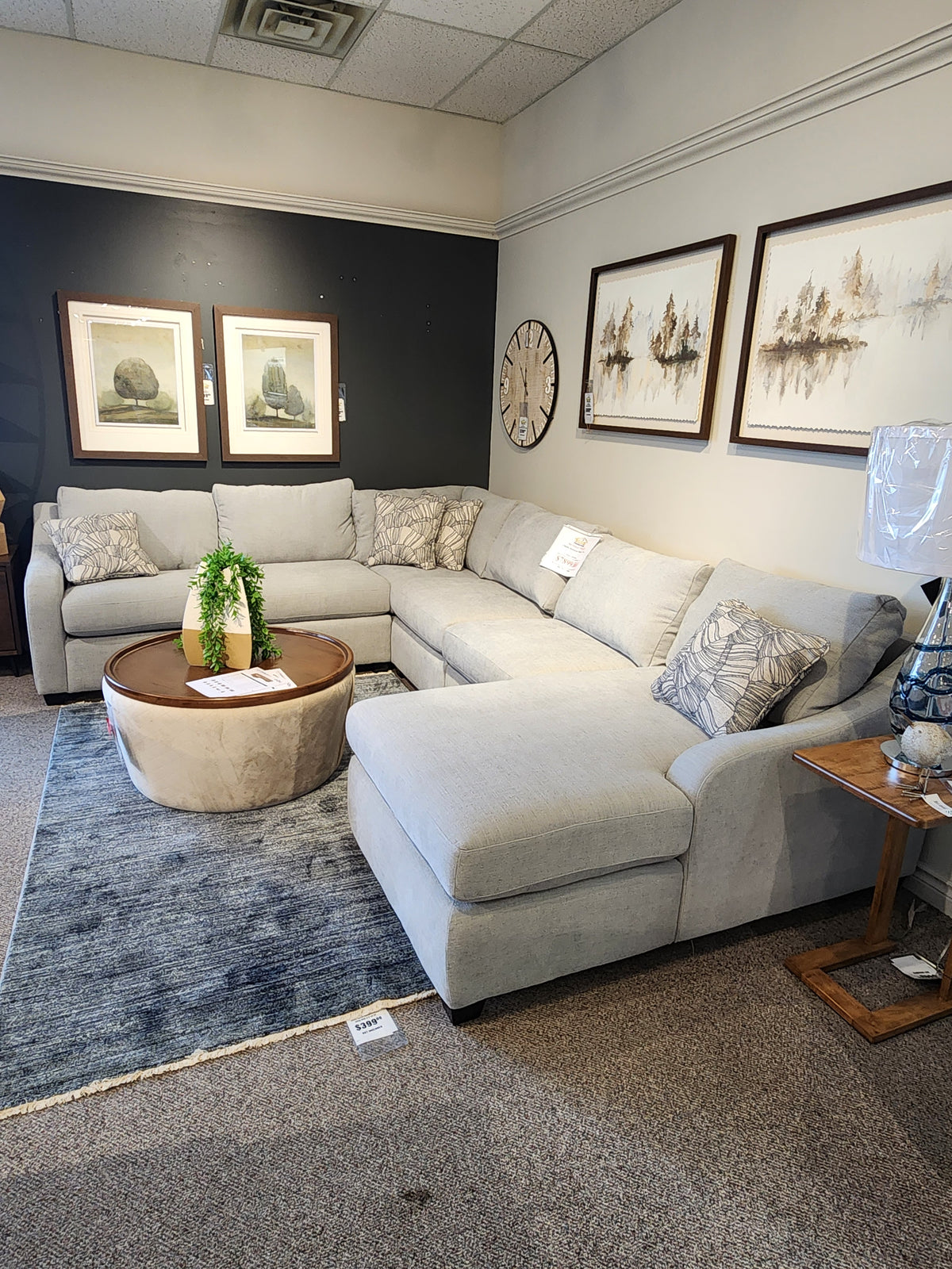 A modern La-Z-Boy Charlie-638 Sectional with patterned pillows is paired with a round coffee table and framed art.
