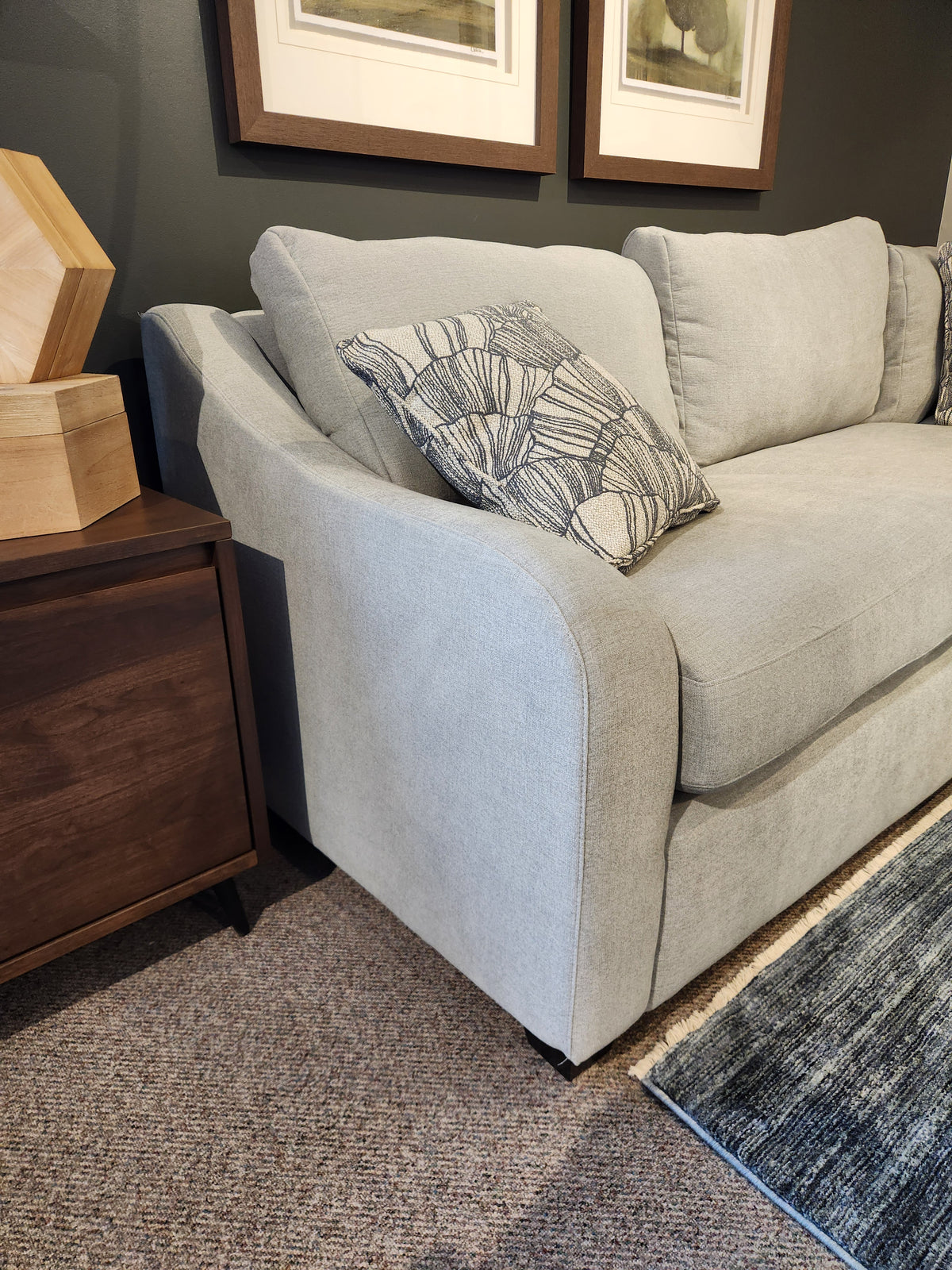 Light gray La-Z-Boy Charlie-638 Sectional with a patterned pillow beside a dark wood table on a blue rug.