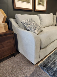 Light gray La-Z-Boy Charlie-638 Sectional with a patterned pillow beside a dark wood table on a blue rug.