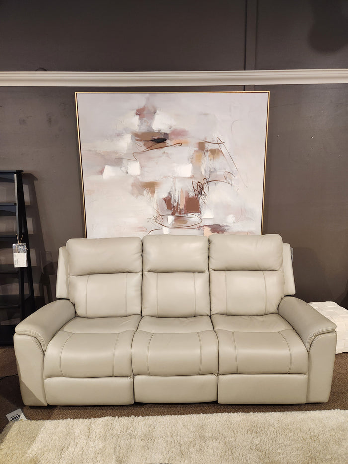 The 16 WEST Austin Power Recliner Sofa-520157 sits by an abstract painting, dark wall, and a light rug beneath.