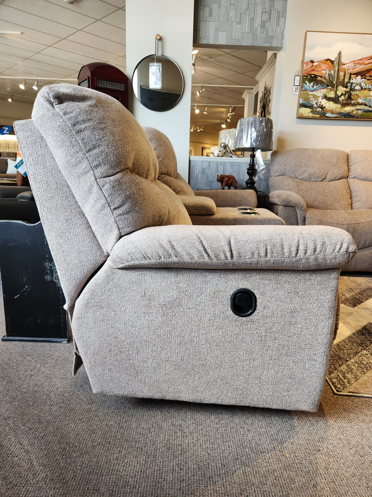 A beige La-z-boy 521 James Loveseat with console, shown in a showroom with other seating in the background.