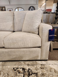 Superstyle 9540 Stationary Sofa, beige with two back cushions, retail tag on arm, patterned rug underneath.