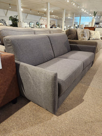 The Primo Vitale Sofa Bed in gray upholstery with Italian mechanism is displayed among other couches in the showroom.