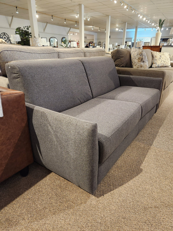 The Primo Vitale Sofa Bed in gray upholstery with Italian mechanism is displayed among other couches in the showroom.