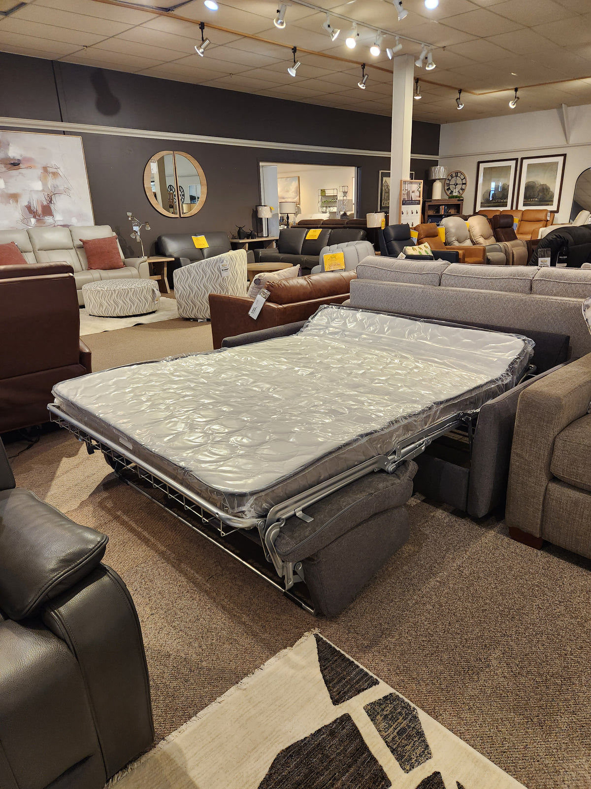 The Primo Vitale Sofa Bed, featuring a memory foam mattress, is showcased among other couches in the showroom.