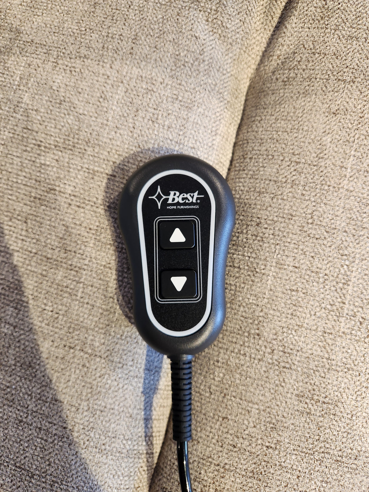 Best"-branded remote for 9N31 Kristisha Power Lift Chair on beige fabric, featuring up/down arrows for lumbar support.