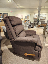 La-z-boy 519 Astor Rocker Recliner with brown upholstery and wooden lever, displayed in a furniture showroom.