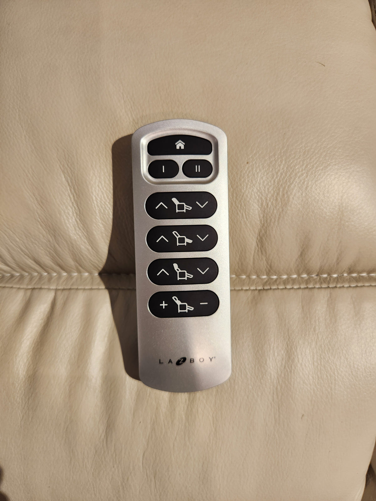 Silver La-Z-Boy remote with black buttons, made for 530 Greyson Power Rocking Recliner, sits on light leather.