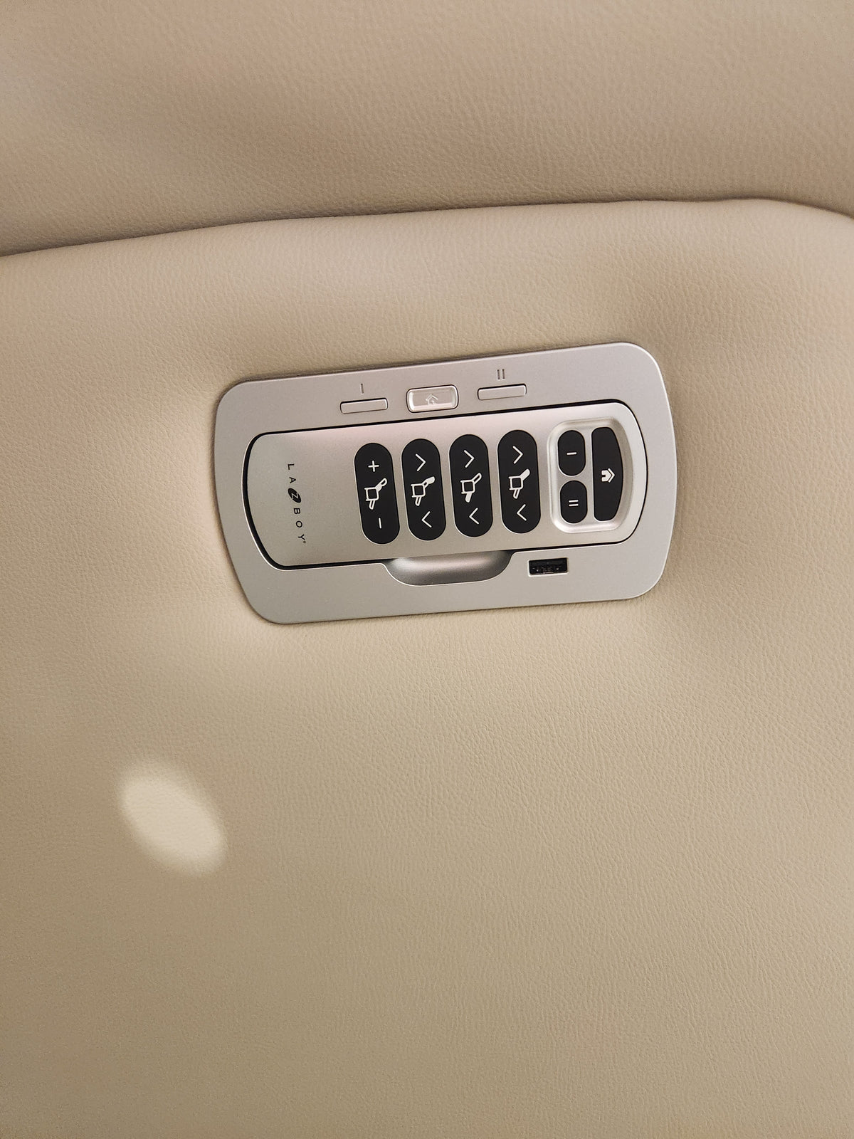 Close-up of La-z-boy 530 Greyson Power Rocking Recliner controls on beige leather—power headrest and lumbar buttons.