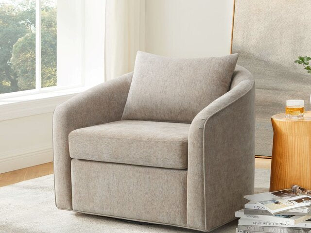 The B6516 Soren Swivel Chair by Donald Choi with cushion sits beside a wooden table and window in a bright room.