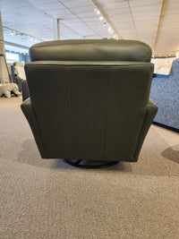 The Leather Craft 745 Leather Swivel Rocker Chair is shown from the back in a carpeted furniture showroom.