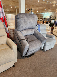 The La-z-boy 793 Jean Bronze Lift Chair is showcased in a showroom, surrounded by other recliners.
