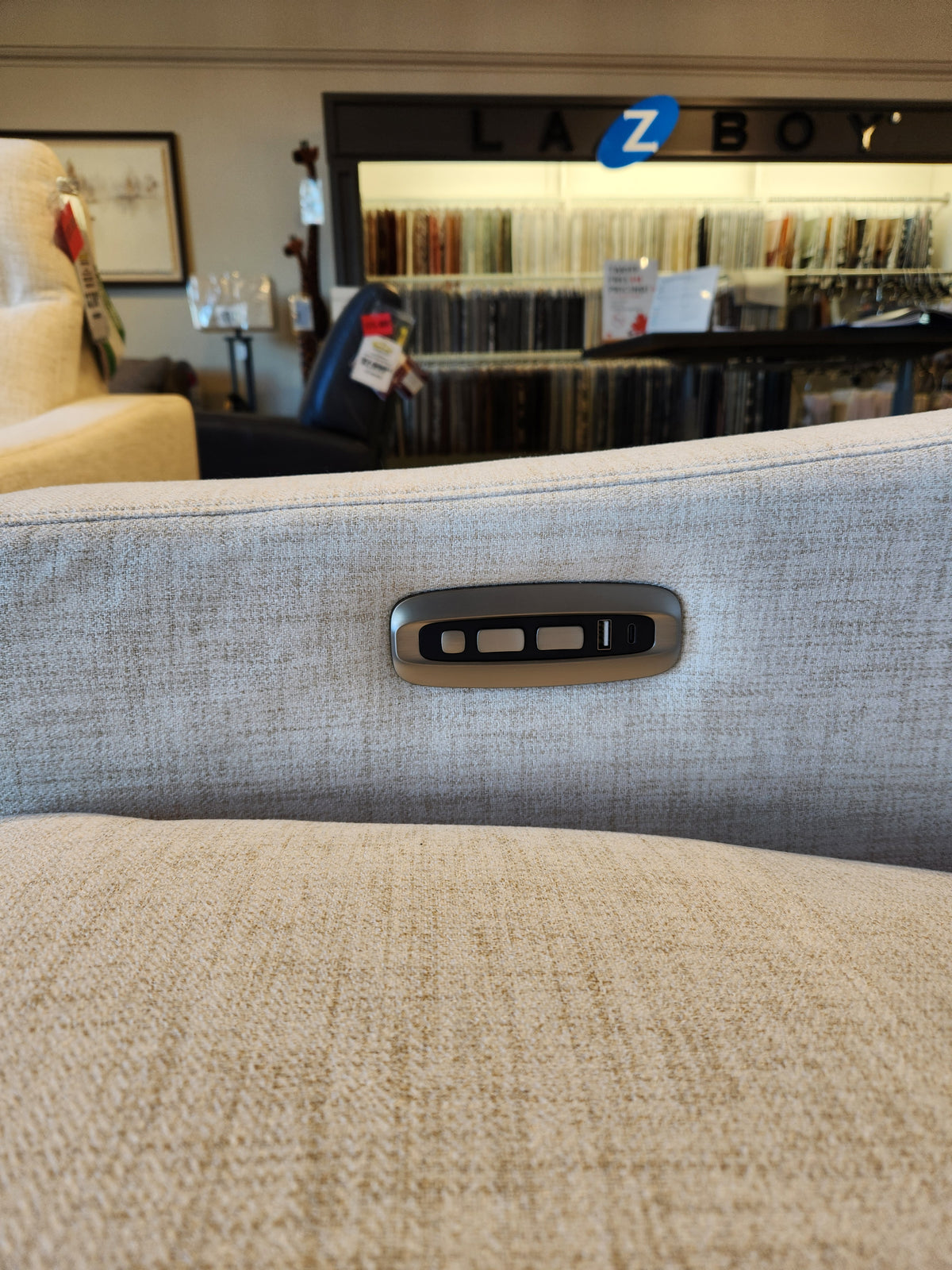 Close-up of the La-Z-Boy 810 Quinault Power Reclining Sofa w/ Zero G & Headrest; fabric samples in background.