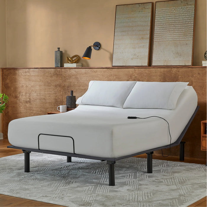 The Beauty-Rest Bronze Adjustable Base features white bedding, a sturdy frame, and a wire remote in a modern bedroom.