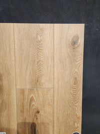 Little Ben XL Luxury Vinyl (Click Plank) by Beckham Brothers, light brown wood grain, shown on a dark textured background.