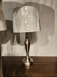 The Glendale 3 Piece Lamp Set by Adesso Lamp features a silver table lamp with a white plastic-covered shade.