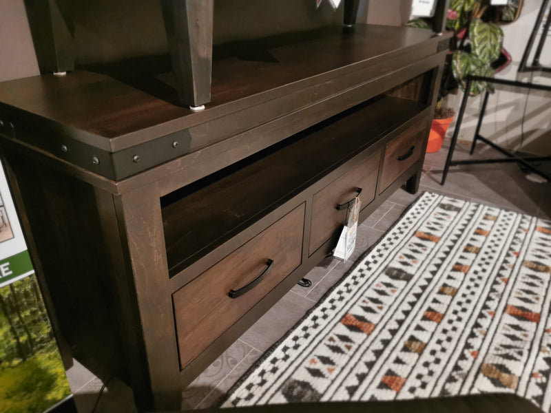 Handstone Chattanooga 74" Media Stand with classic design sits on a patterned rug in a cozy room.