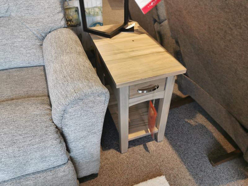 A Handstone N-GG2413 Glengarry Chair Side Table with drawer and shelf sits by a gray sofa on carpeted flooring.