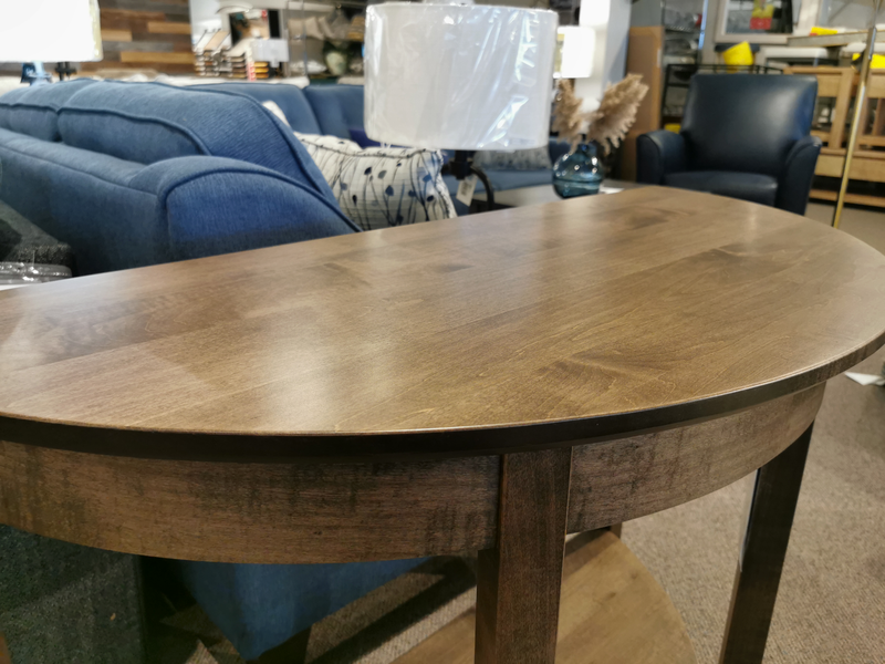 The Handstone Demi-Lune Sofa Table pairs with blue couches and lamps for an elegant, refined furniture accent.