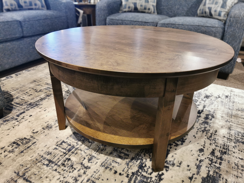 Handstone Demi-Lune Coffee Table with lower shelf sits on a patterned rug in the living room.