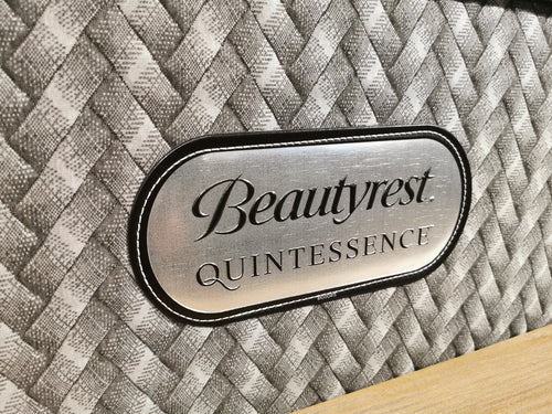 Close-up of a mattress corner with woven pattern, featuring Beauty-rest's Quintessence Hybrid Plush and WinterCool™ label.