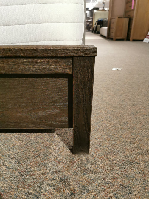 Close-up of the 11 Fundamental Panel Double Bed by Vaughan Bassett on a carpeted floor in a store.
