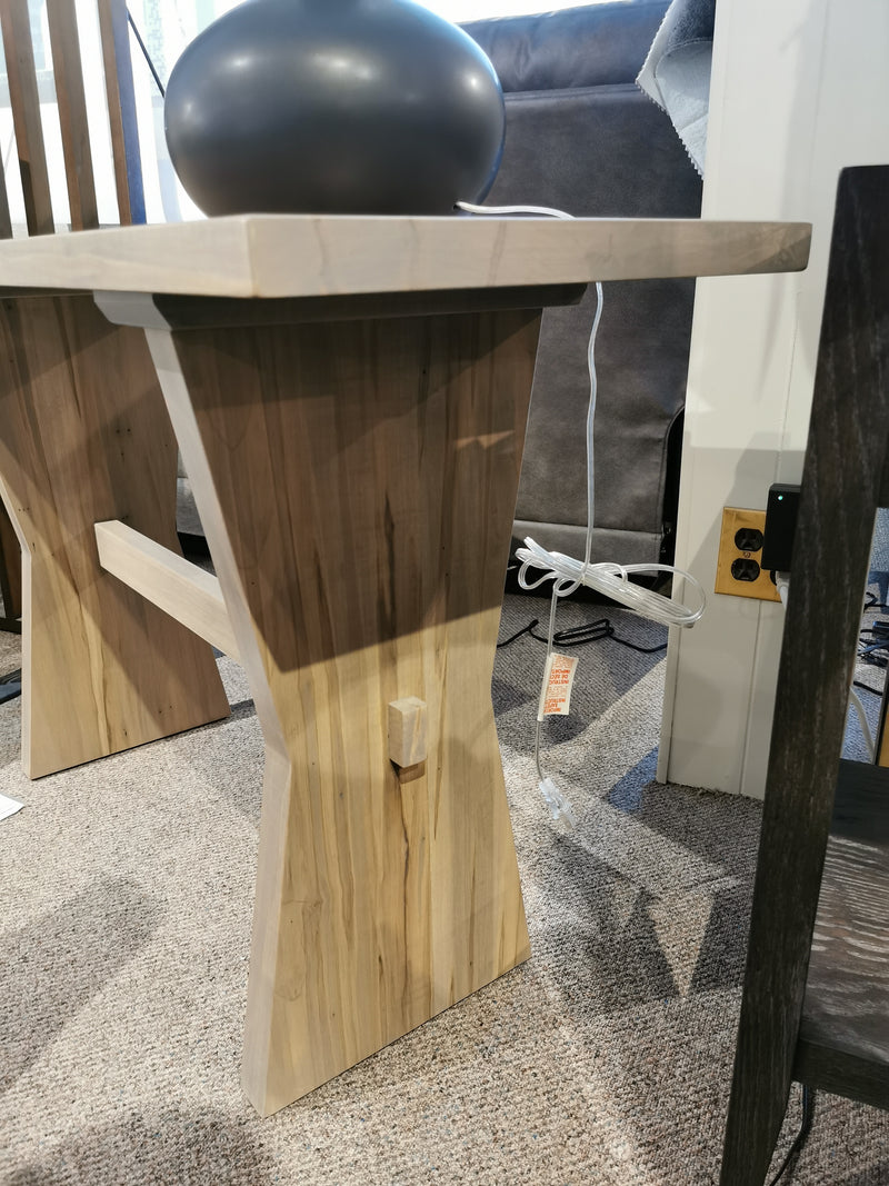 Handstone JA120 Jasper Sofa Table in light wood with a dark vase, power outlet, and white cord on carpeted floor.