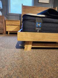A Handstone JA-QW Jasper Queen Platform Bed with a Sealy mattress stands on carpet by a wooden nightstand.