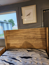 The Handstone JA-QW Jasper Queen Platform Bed sits by a window, beneath a framed bird print.