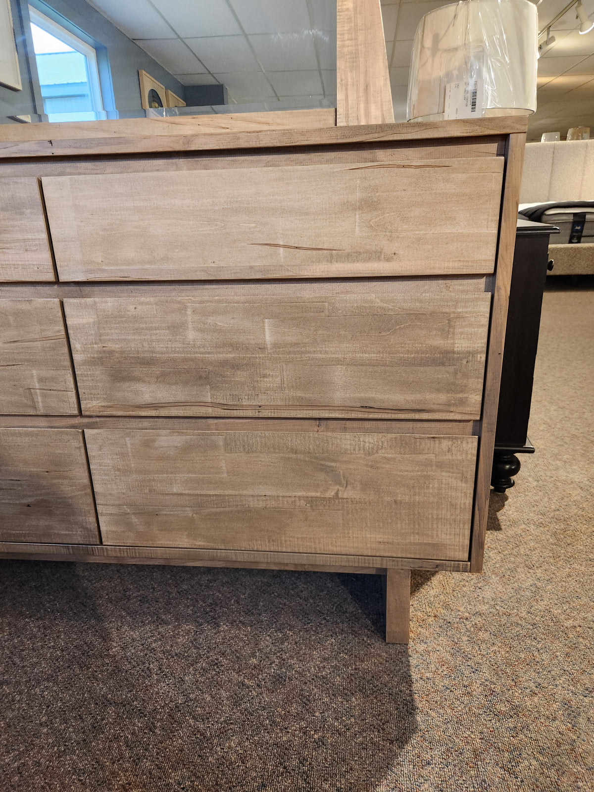 Handstone JA18 6 Drawer Dresser in light wood from the Jasper Collection, shown with lamp on top in carpeted room.