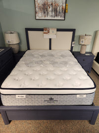 A queen-size KingsDown Radiance Elite 2 ET Firm Mattress offers cooling comfort, flanked by nightstands with lamps.