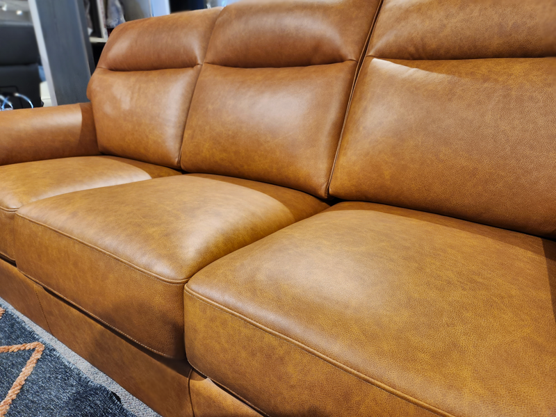 Close-up of the Leather Craft Norway Leather Sofa, a custom three-seater with top-grain leather, in a showroom.
