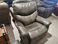 A gray 521 James Rocker Recliner by La-z-boy is shown in a furniture showroom with other chairs in the background.