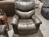 A gray La-z-boy 521 James Rocker Recliner with a bucket seat is displayed in the furniture showroom.