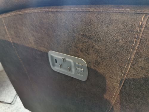 Close-up of a La-Z-Boy 724 Trouper Power Swivel Recliner's USB outlet on brown leather-like surface, featuring modern design.