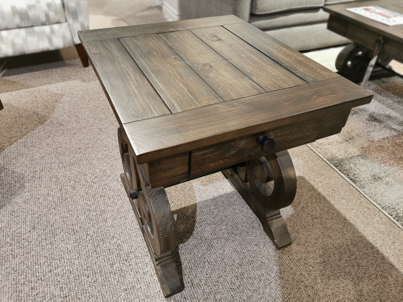 Magnussen 2491 Bellamy End Table with drawer, carved base, and metal supports stands on carpeted floor.