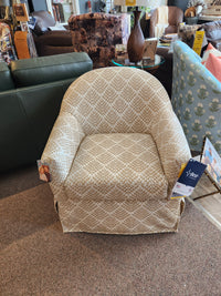 Meg Swivel Chair by Best, featuring a beige barrel back and skirted slipcover, displayed in-store.