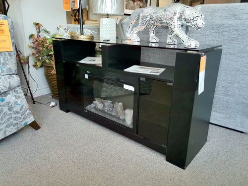 Foley Electric Fireplace Mantel in black with glass doors and a silver leopard, featuring a Napoleon insert, displayed in-store.