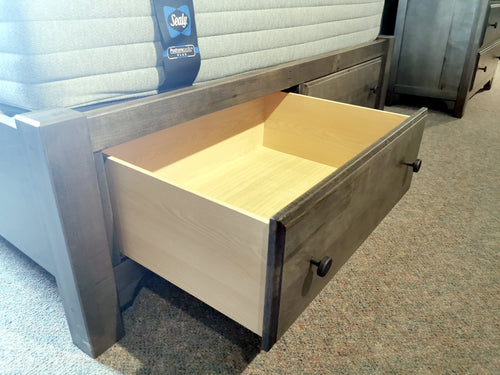 The Vaughan Bassett Cool Farmhouse 801 Queen Bed has a mattress on top and a storage drawer in the footboard.