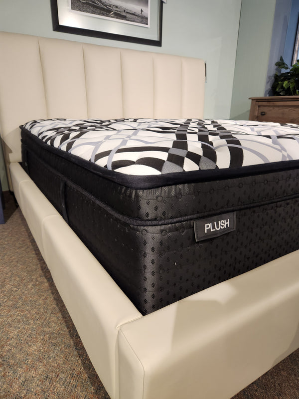 The KingsDown Vermillion ET Firm Mattress features a geometric pattern on a cream upholstered frame for optimal sleep.