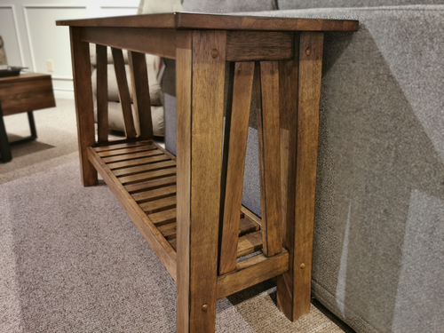 The NP100S Newport Sofa Table, by Winners Only, features a slatted shelf and sits against a gray couch on carpet.
