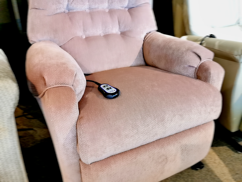 The Sondra Power Lift Chair by Best is a luxurious plush pink recliner with a motorized recline feature and a sleek black remote control on the seat, offering an ideal space-saving design for those seeking comfort and elegance.