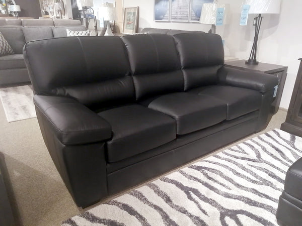 The Leather Craft Colorado sofa rests on a zebra-patterned rug in a showroom.