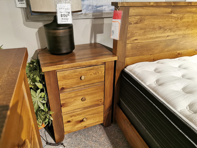The Vokes 850 Roughsawn 3-Drawer Night Table, solid wood, sits beside a bed in Owen Sound, Ontario.